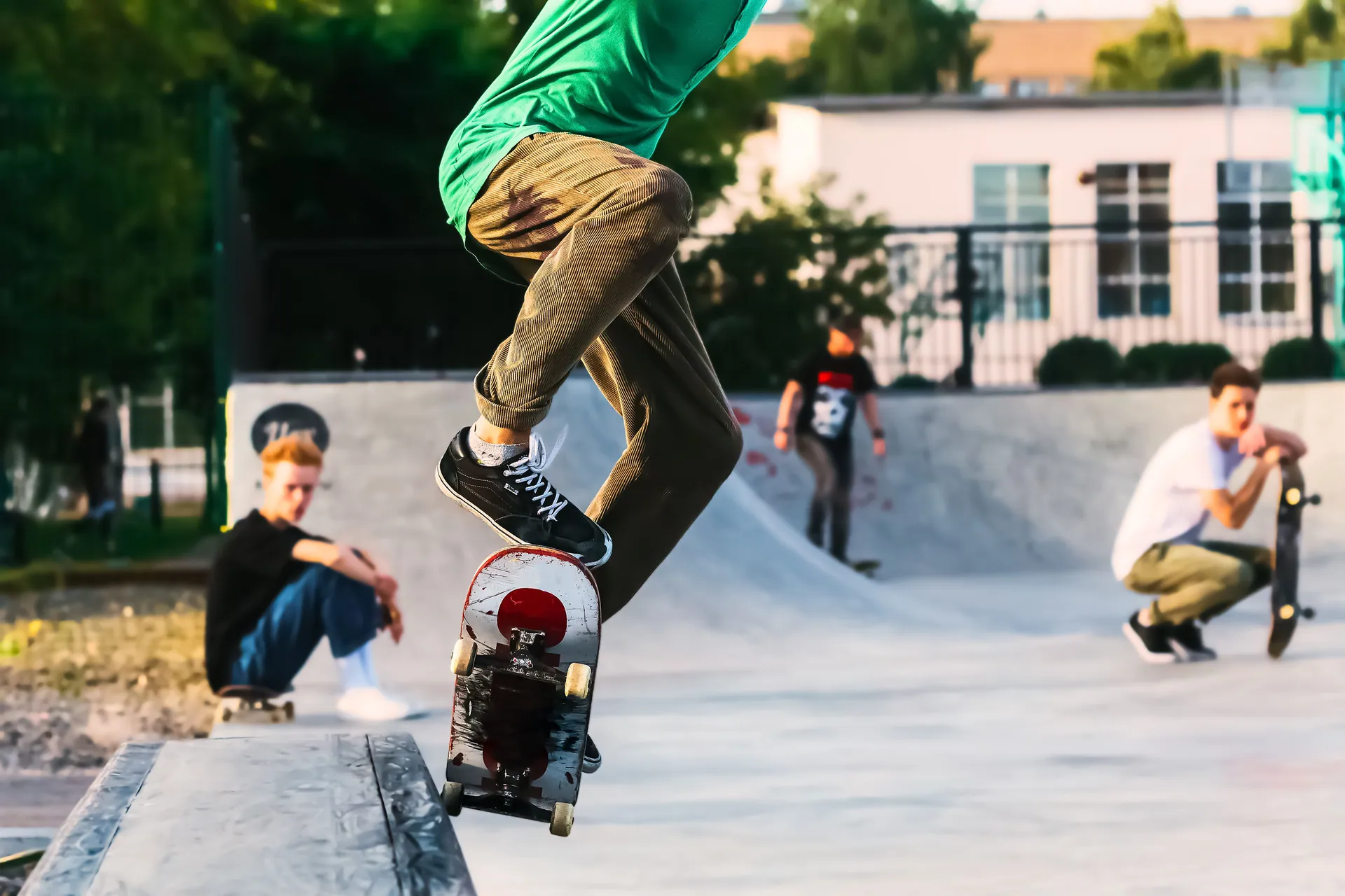 Young skateboarder performing a trick at an urban skatepark on a sunny day.
