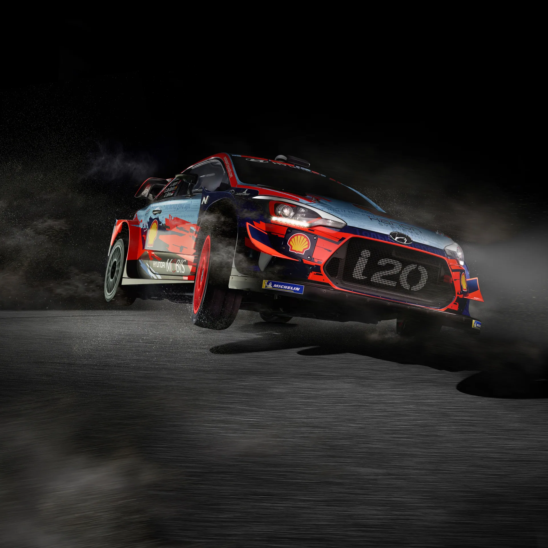 High-speed rally car skidding on dirt track at night, showcasing thrilling motorsport action.