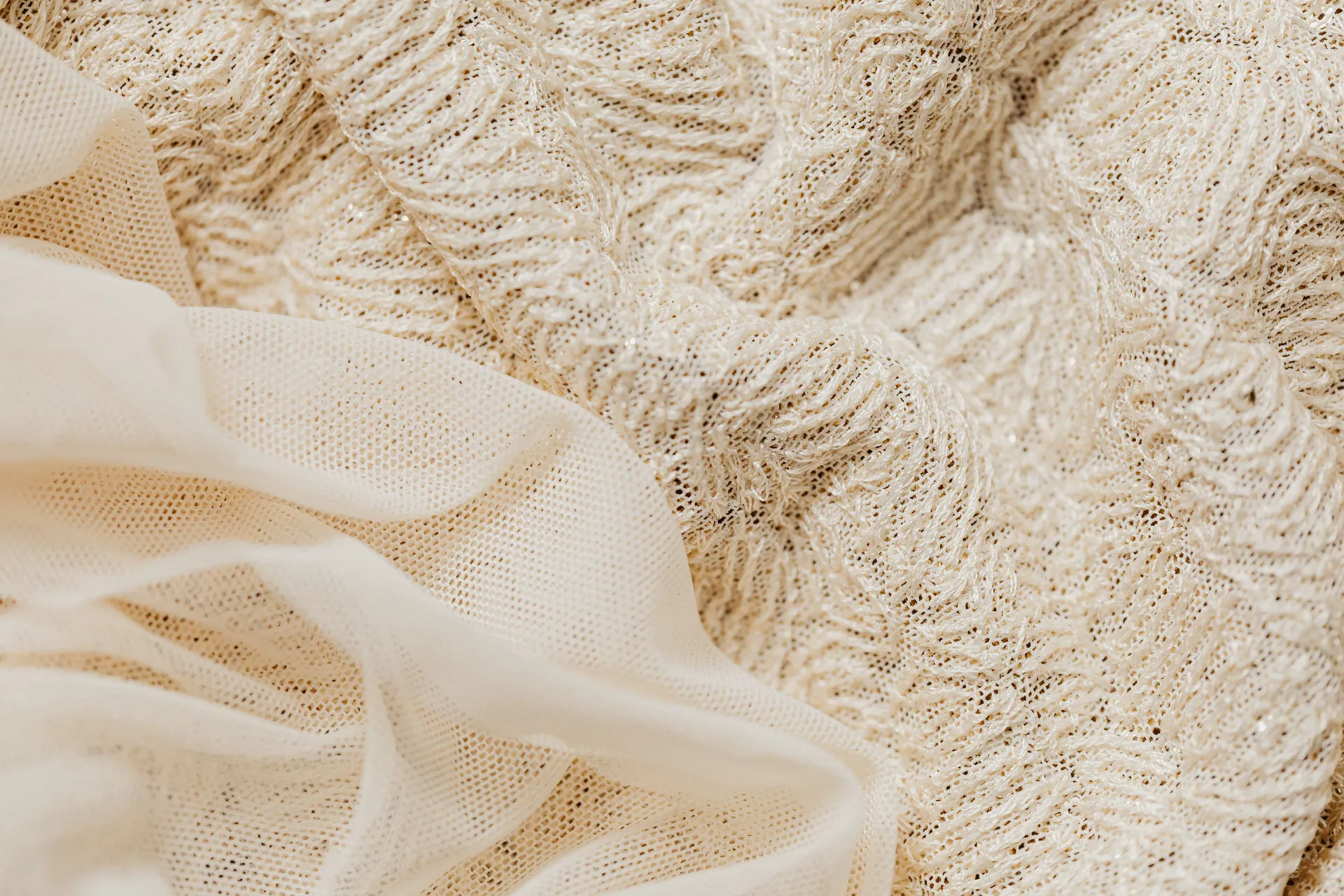 Close-up view of intricate beige lace fabric and sheer material, ideal for fashion and textile projects.