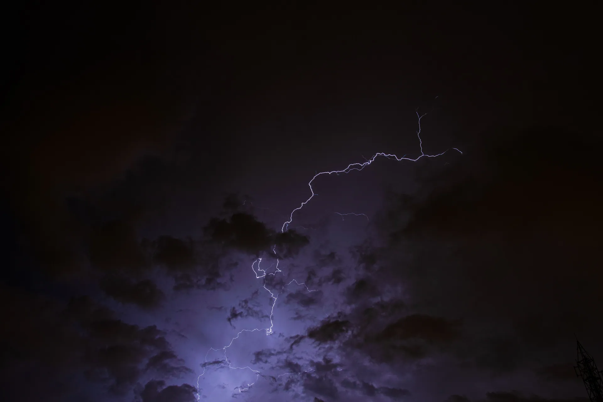 A captivating view of lightning striking through a dark, cloudy night sky.
