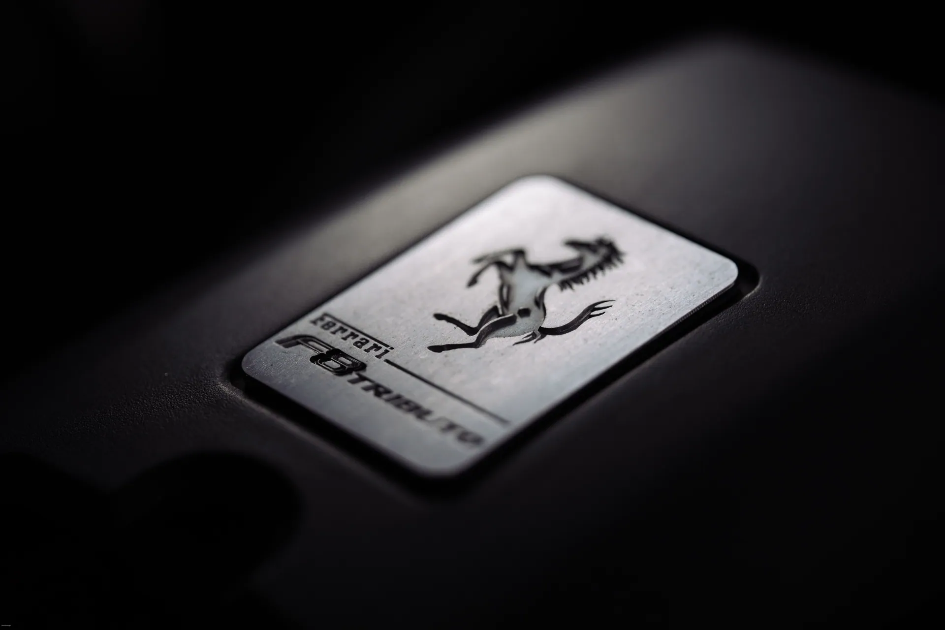 Close-up of a metallic car logo badge with a prancing horse, symbolizing luxury and speed.