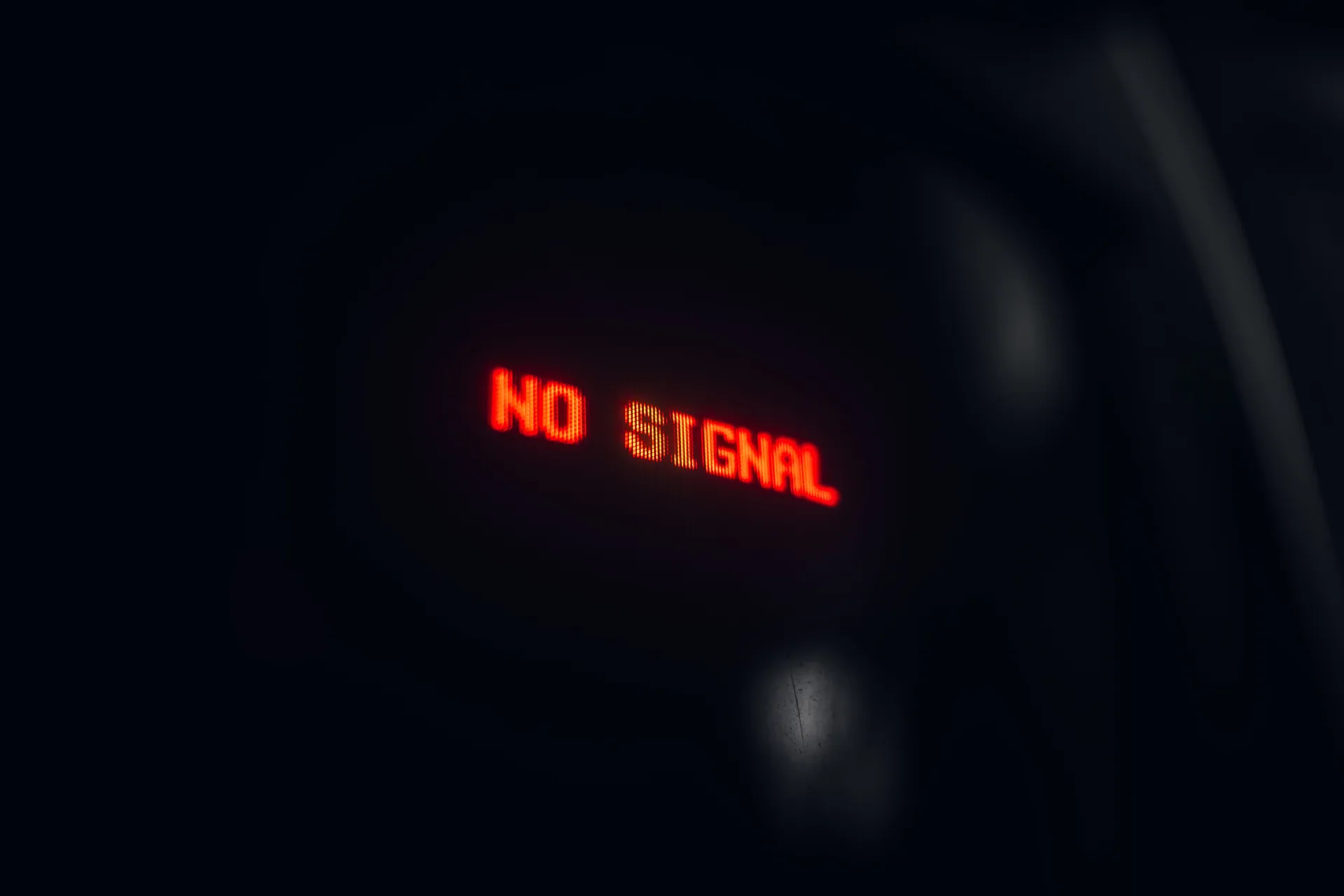 A red LED display indicating 'No Signal' in a dark setting, conveying a tech warning.