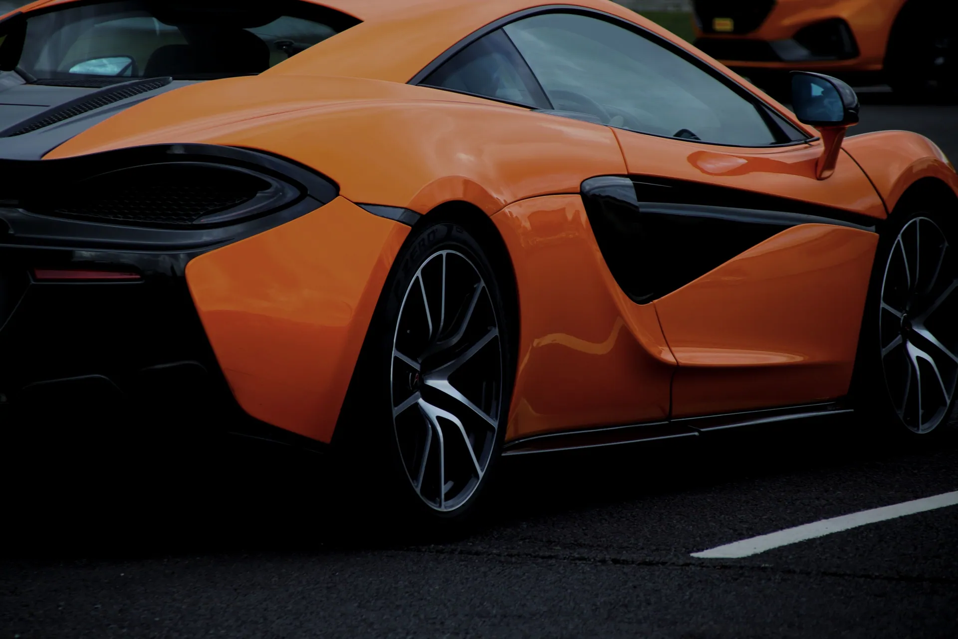 A dynamic shot of an orange sports car on a road in England, United Kingdom.
