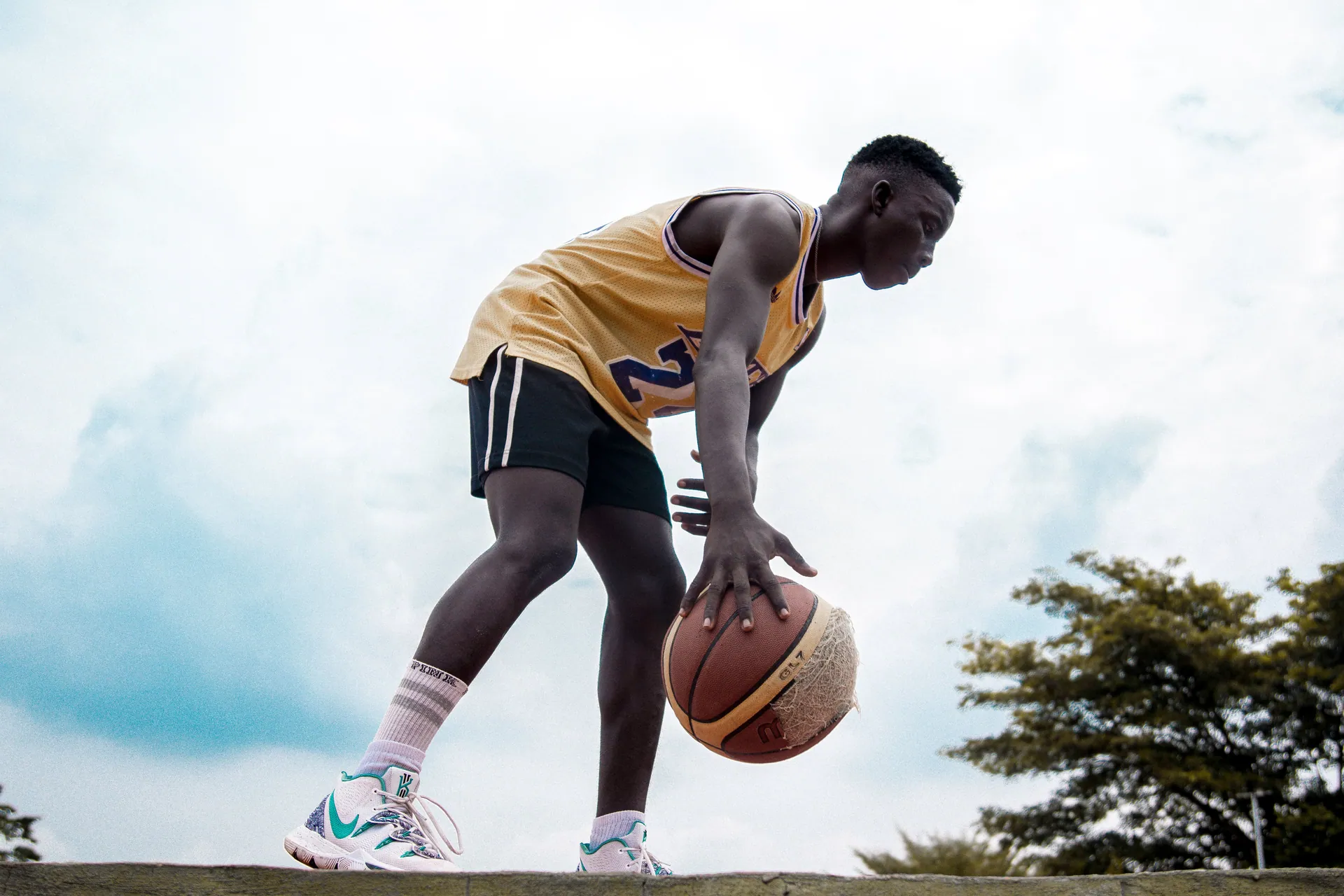 Young basketball player dribbling outdoors, showcasing skill and determination.