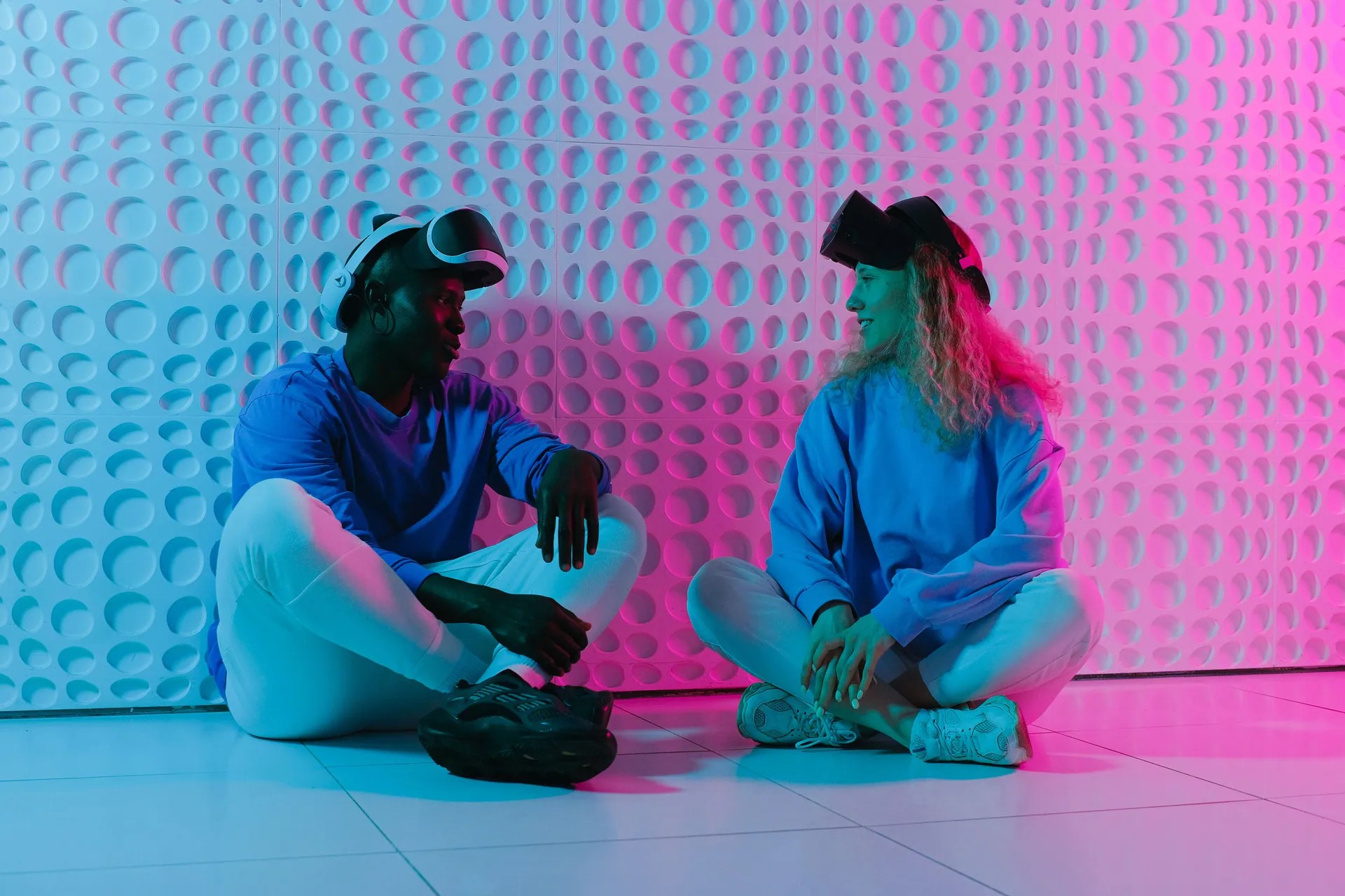 Two people engage with VR headsets in a futuristic, colorful environment.