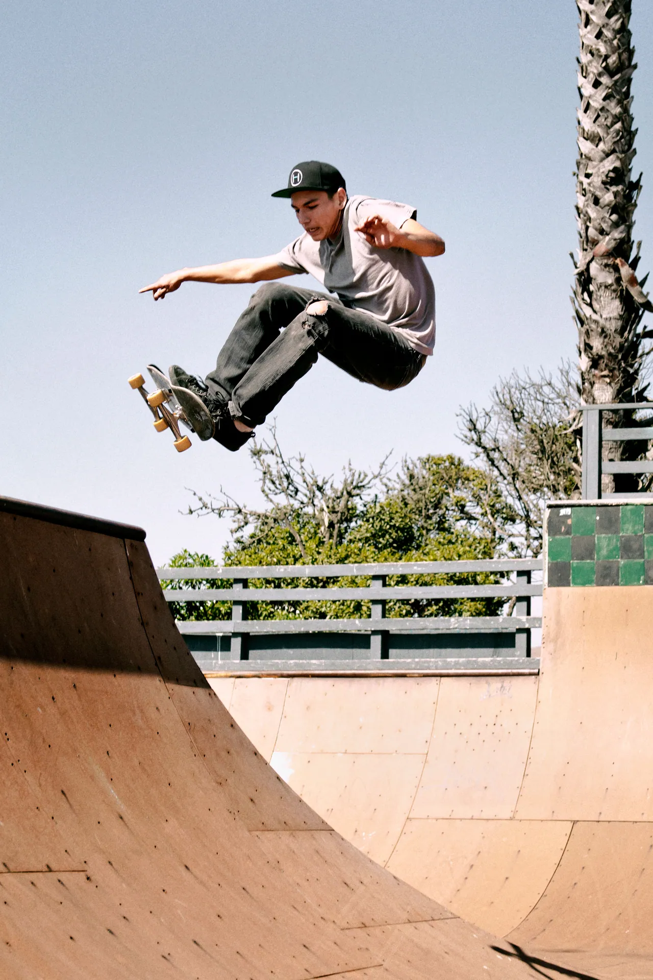 A teenage skateboarder performing a high-flying trick at an outdoor skate park in Cayucos, California.