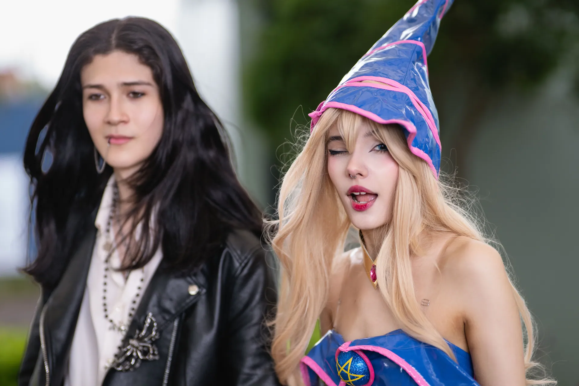 Two individuals dressed in anime-inspired cosplay at an outdoor convention in San José, Costa Rica.