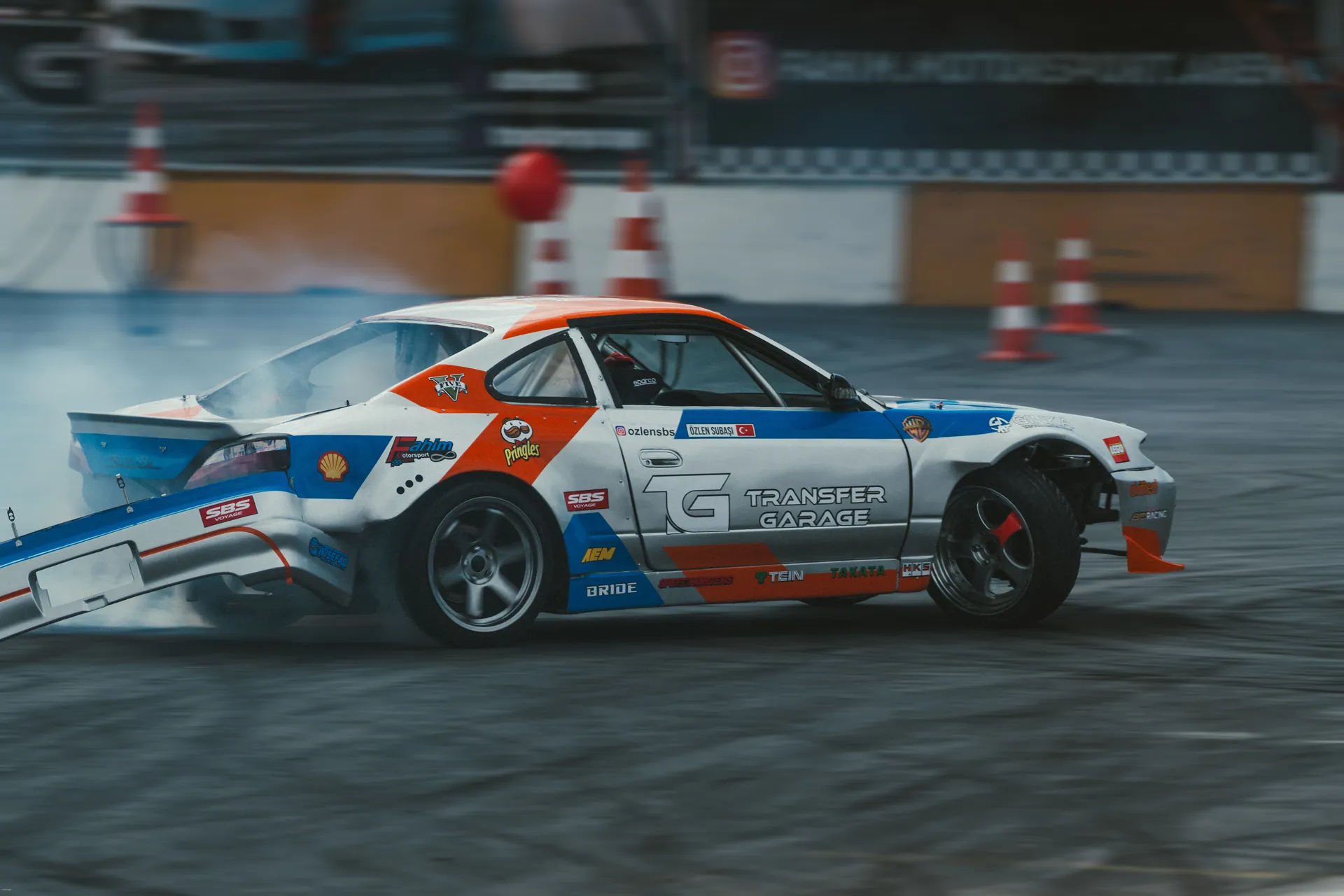 A dynamic action shot of a colorful drift car racing on an indoor track, showcasing speed and motion.