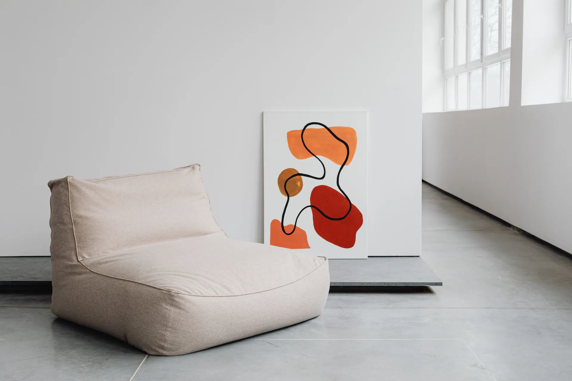 A contemporary interior featuring abstract artwork and a minimalist chair.