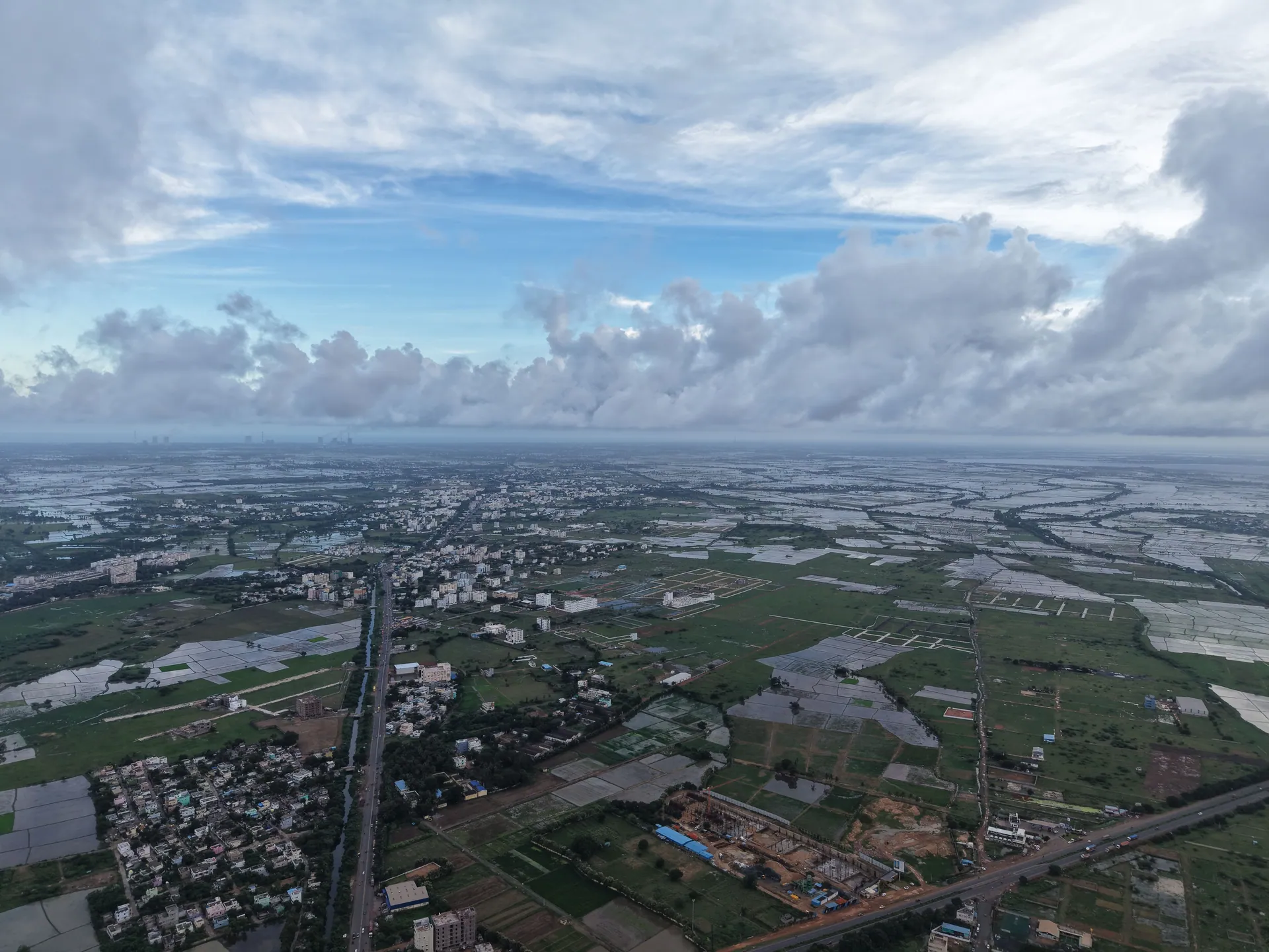 A breathtaking aerial shot capturing a vast countryside landscape with distant skyline views on a cloudy day.