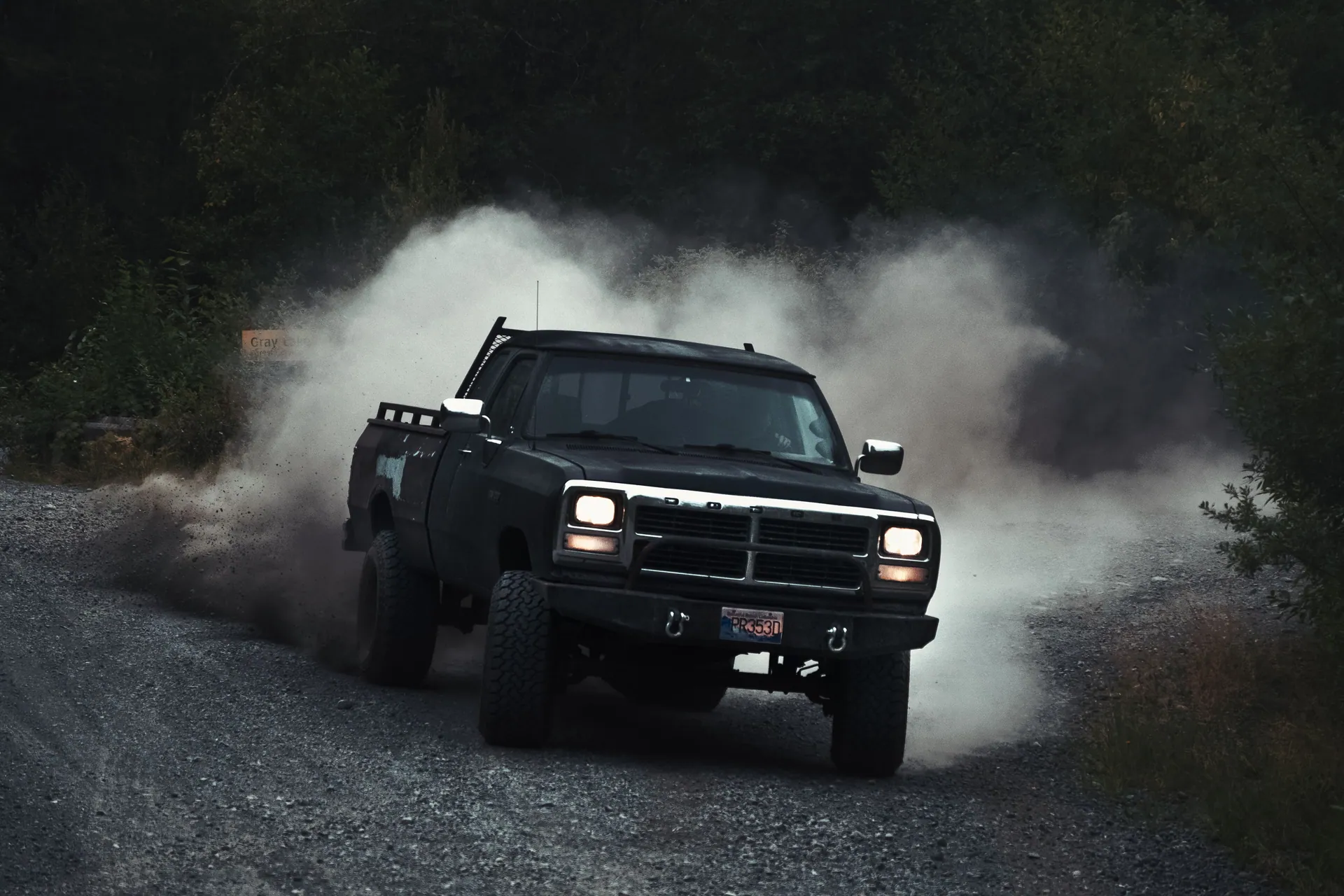 A powerful pickup truck speeding on a dirt road, creating a dramatic dust cloud.