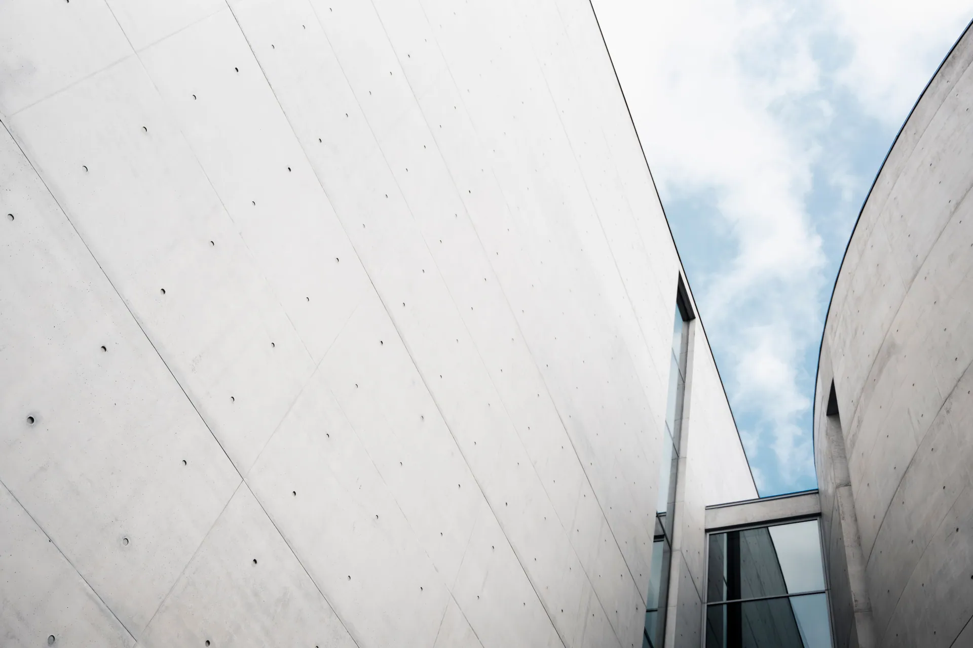 Minimalist architectural structure against a blue sky, showcasing sleek lines and simplicity.