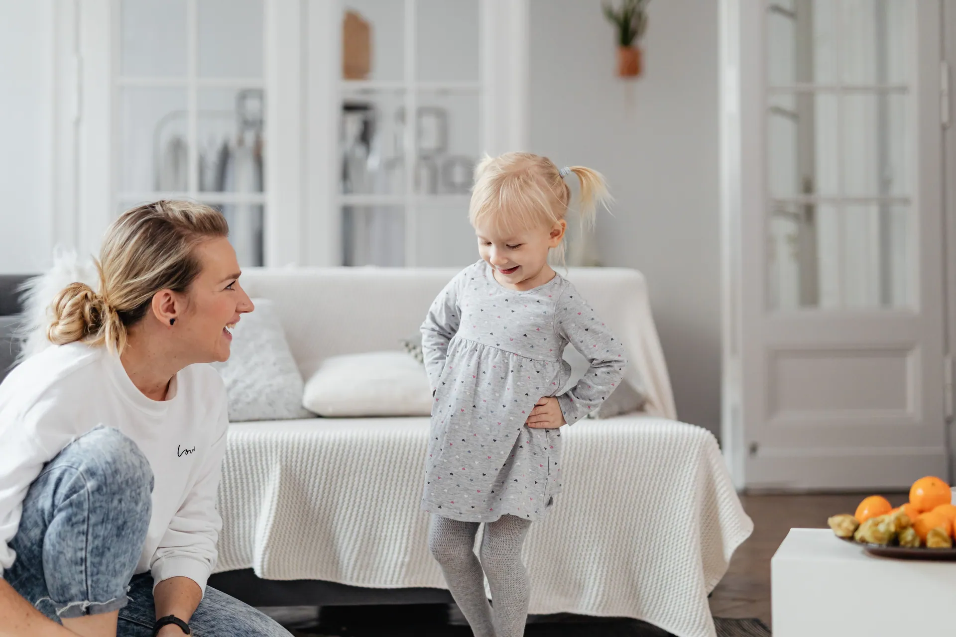 A mother and daughter sharing a joyful moment together in a cozy living room setting.