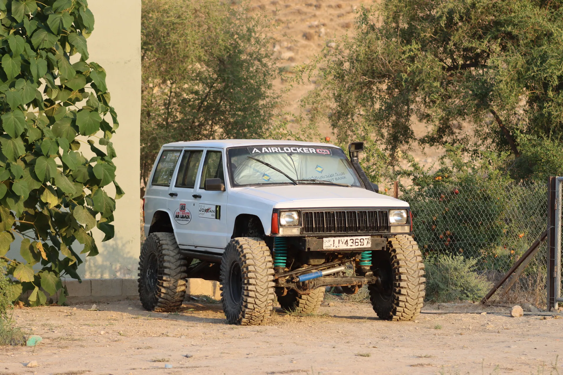 Rugged off-road SUV parked in Amman, Jordan surrounded by greenery and desert terrain.
