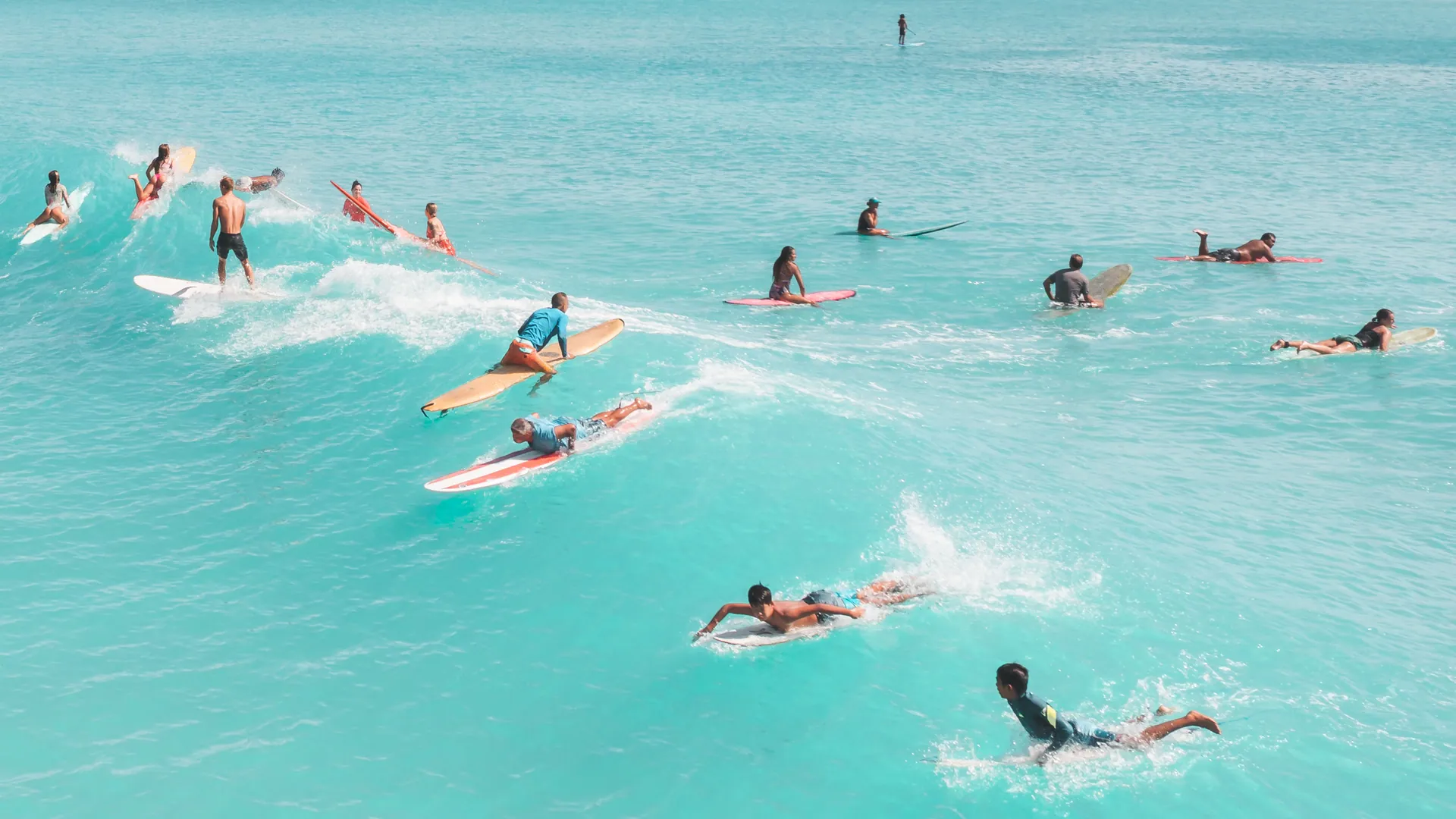 A group of surfers enjoying the bright ocean waves during summer, displaying vibrant leisure and sport.
