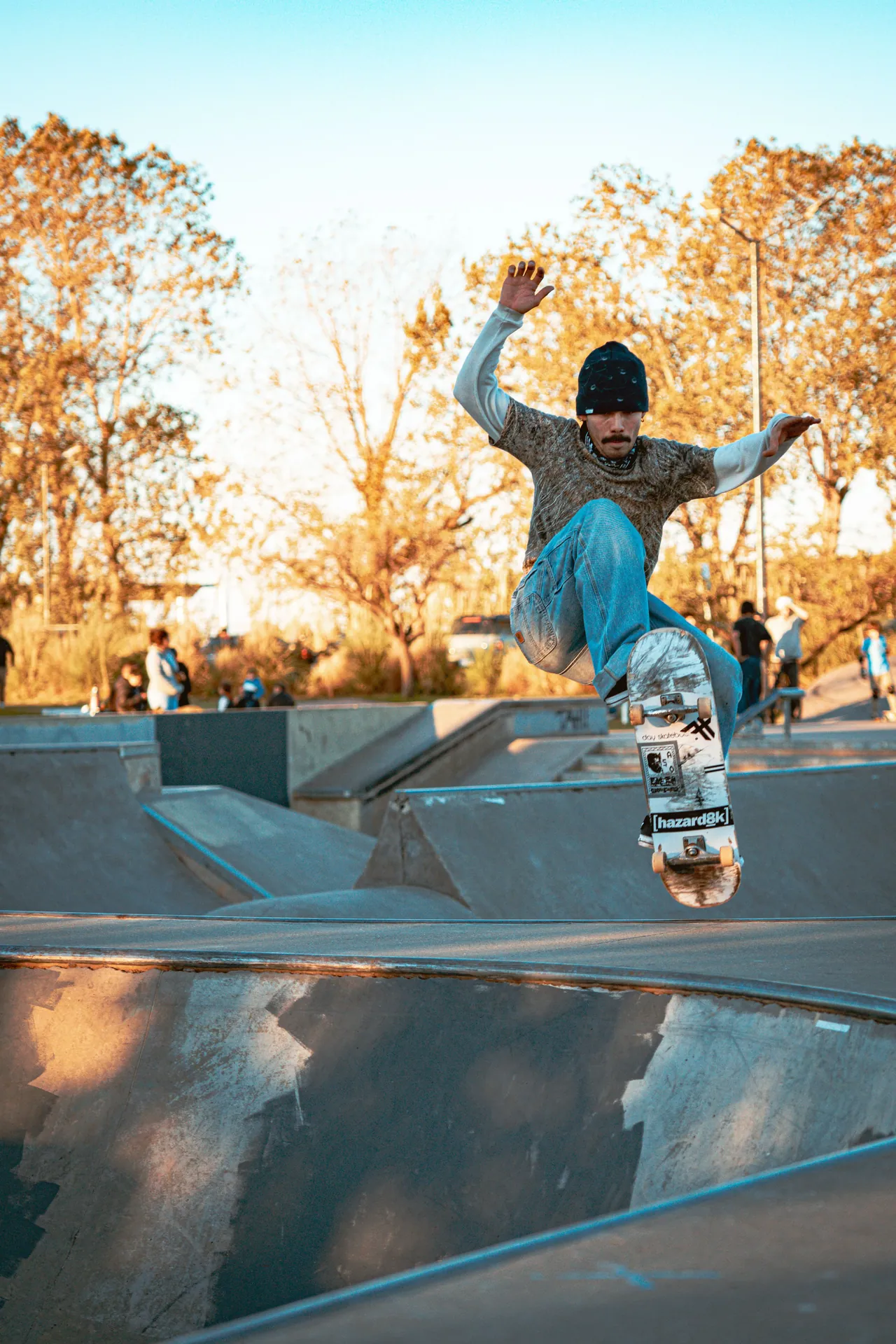 A skateboarder in mid-air executing a trick in a skatepark during daylight in Buenos Aires.