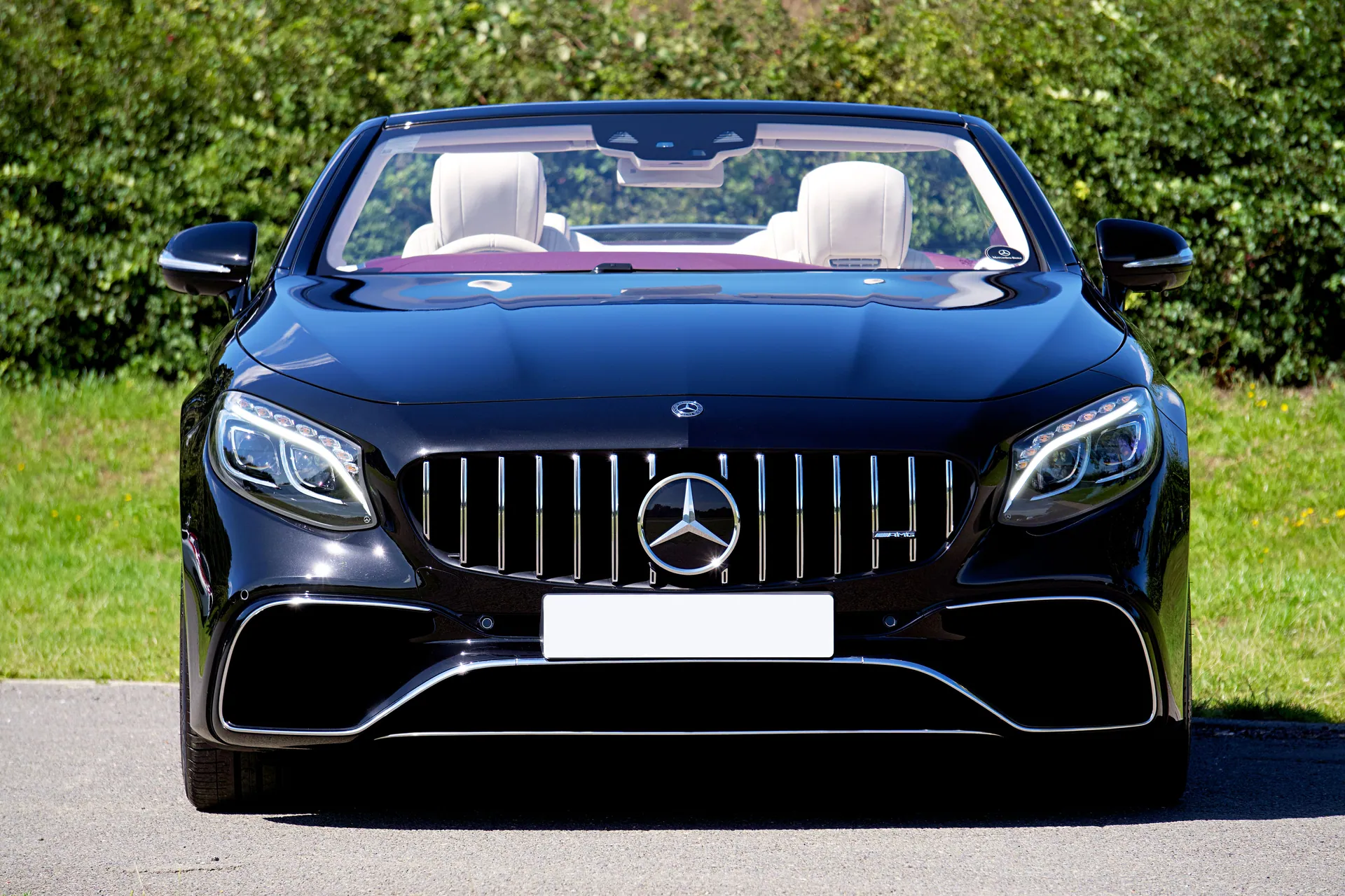 Front view of a sleek black Mercedes-Benz convertible parked on a sunny day.