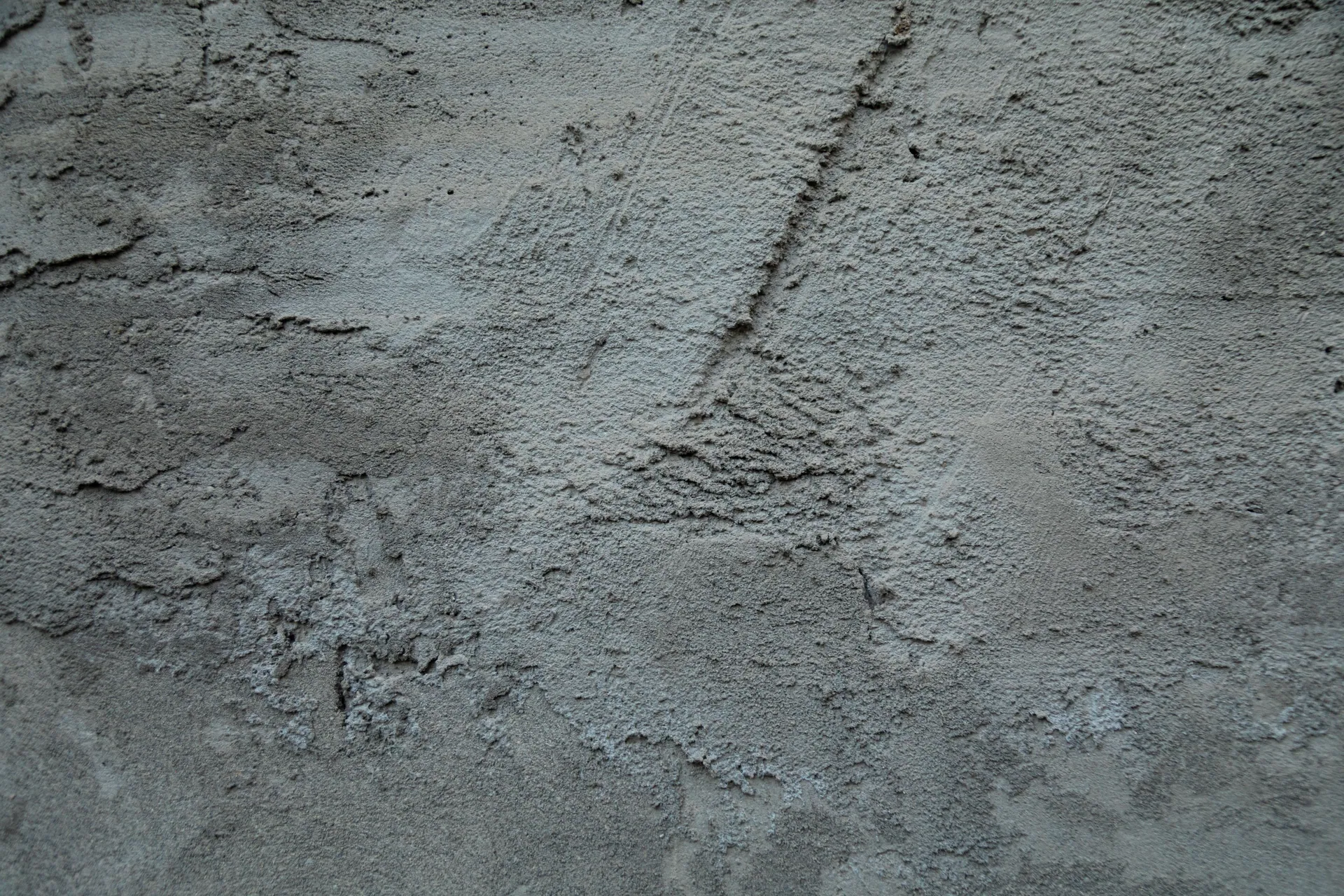 Detailed view of textured concrete wall with rough, rugged surface features.