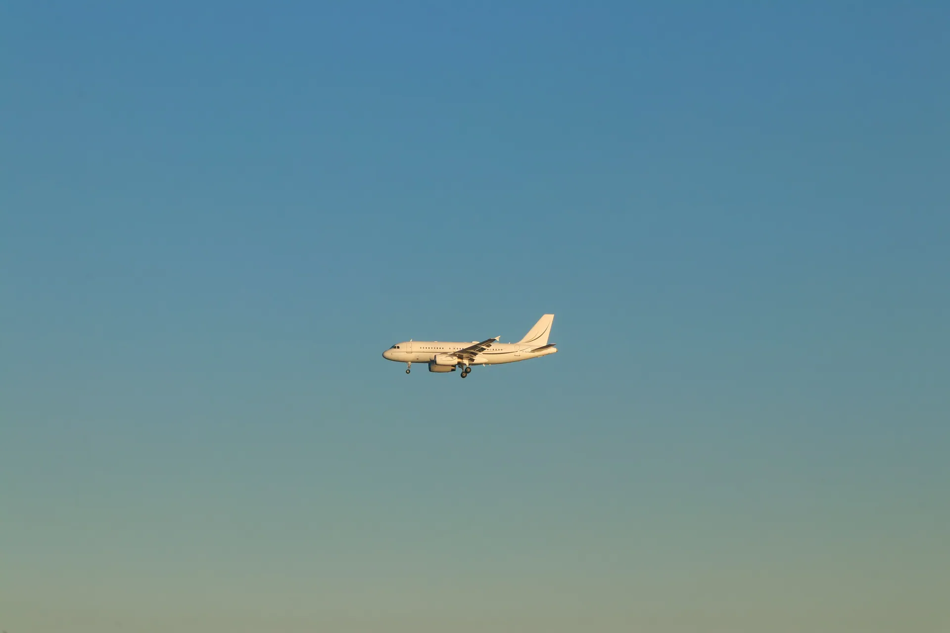 A commercial airplane flying against a clear blue sky during the day in Istanbul.
