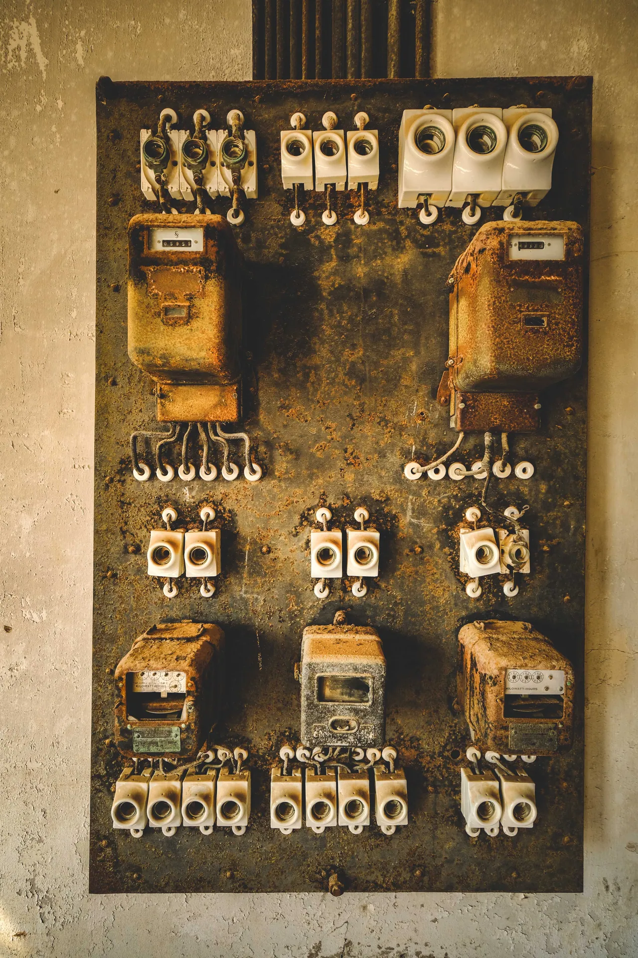 A detailed close-up of a rusty vintage electrical control panel with fuses and meters.