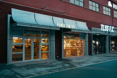 Front view of Panda Comics store with illuminated shelves showcasing comic books.