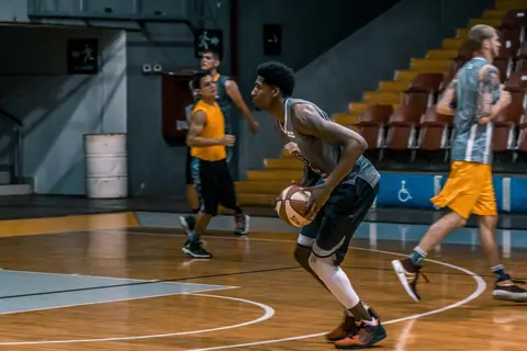 Young athletes engage in a dynamic basketball practice indoors, focused on skill development.