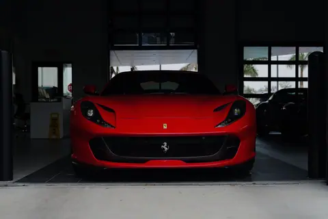 A striking red sports car parked in a contemporary garage setting, showcasing luxury design.