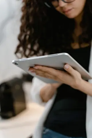 Close-up of a woman holding a tablet, capturing a focused office environment.