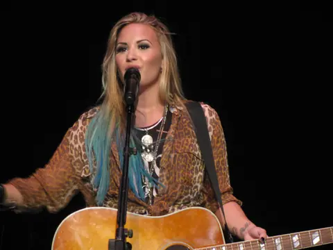 Demi Lovato playing the guitar smile