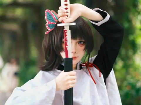 Anime-inspired character holding a sword outdoors with butterfly hairpin and vibrant costume.