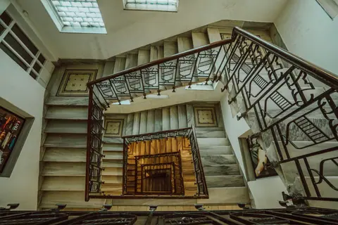 Top-down view of a spiral staircase with ornate metal railings and geometric designs.