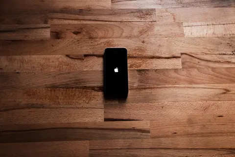 A smartphone lying on a natural wooden surface creating a minimalist aesthetic.