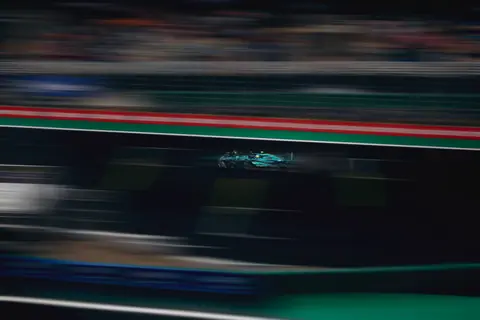 Blurred motion of a racing car speeding on a track during a competitive race.