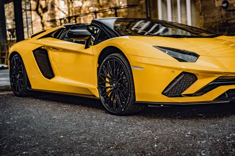Sleek yellow sports car parked on an asphalt street in Dubai, showcasing luxury and design.