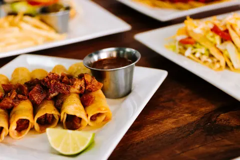 Delicious tacos with meat and lime served on a wooden table, showcasing vibrant Mexican cuisine.