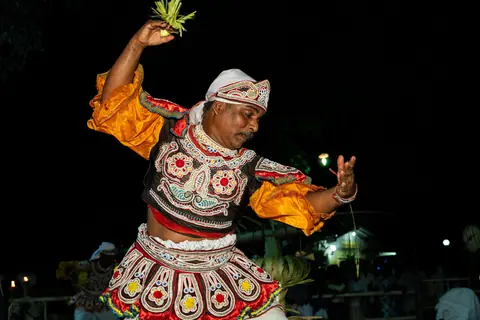 A vibrant traditional Kandyan dance performance in Gampaha, Sri Lanka at night.