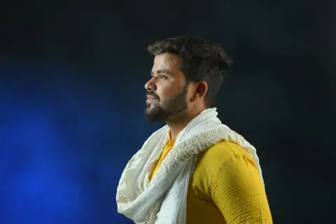 Side profile portrait of a man wearing yellow kurta and white scarf, showcasing traditional Indian culture.