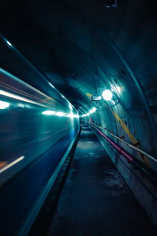 Blurred train rushing through a dimly lit underground tunnel in Milan, Italy.