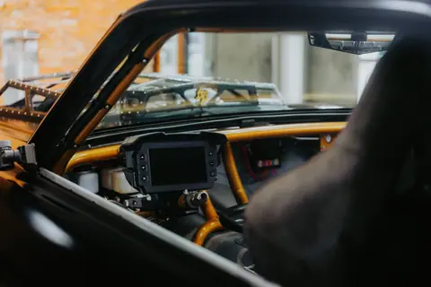 Close-up of a race car cockpit showcasing the dashboard and controls inside a modified vehicle.