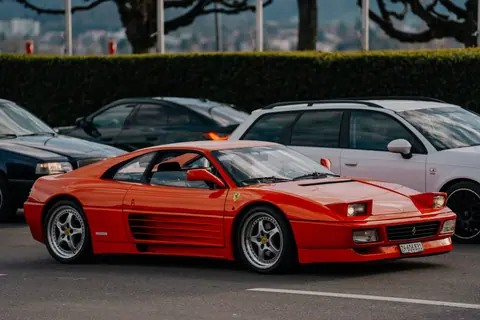 Vintage red sports car parked on a street in Zürich, Switzerland. Perfect for automotive and urban themes.