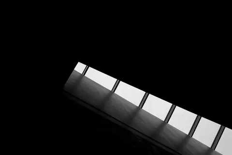 Dynamic black and white abstract image featuring ceiling windows with architectural lines.