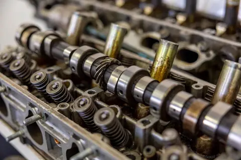 Detailed view of camshaft inside an engine block illustrating mechanical engineering.