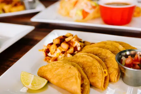 Close-up of appetizing tacos with salsa and lemon, capturing Mexican cuisine delights.