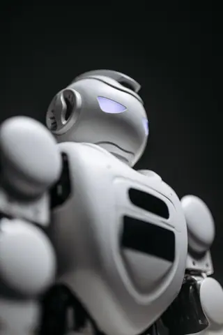 Close-up of a futuristic robot with glowing blue eyes, showcasing advanced technology and design.