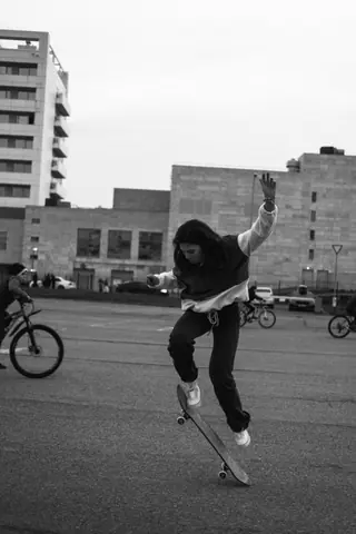 A skateboarder executes a trick in an urban area, showcasing skill and style.