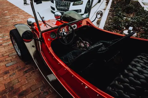 A classic Volkswagen buggy with a retro interior at an outdoor car show.