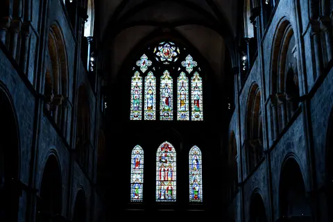 Gothic stained glass windows inside Chichester Cathedral, showcasing intricate religious artistry.