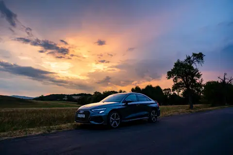 Elegant Audi sedan parked on a scenic Slovak road at sunset.