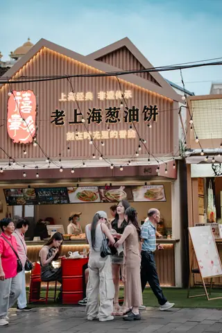 Bustling street food stall in Shanghai offering traditional snacks, captured with vibrant crowd interactions.