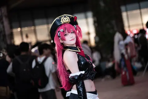 Anime cosplay enthusiast in vibrant costume at an outdoor convention event.